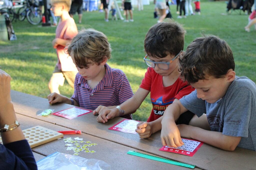 Three young boys looking down at their bingo cards