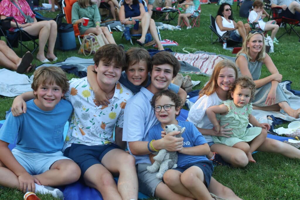 Group of six boys and two girls smiling together.