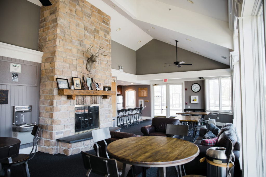 inside of the platform tennis hut with fireplace and seating areas