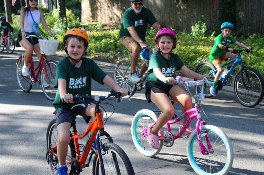 Young boy and girl biking and smiling at the camera