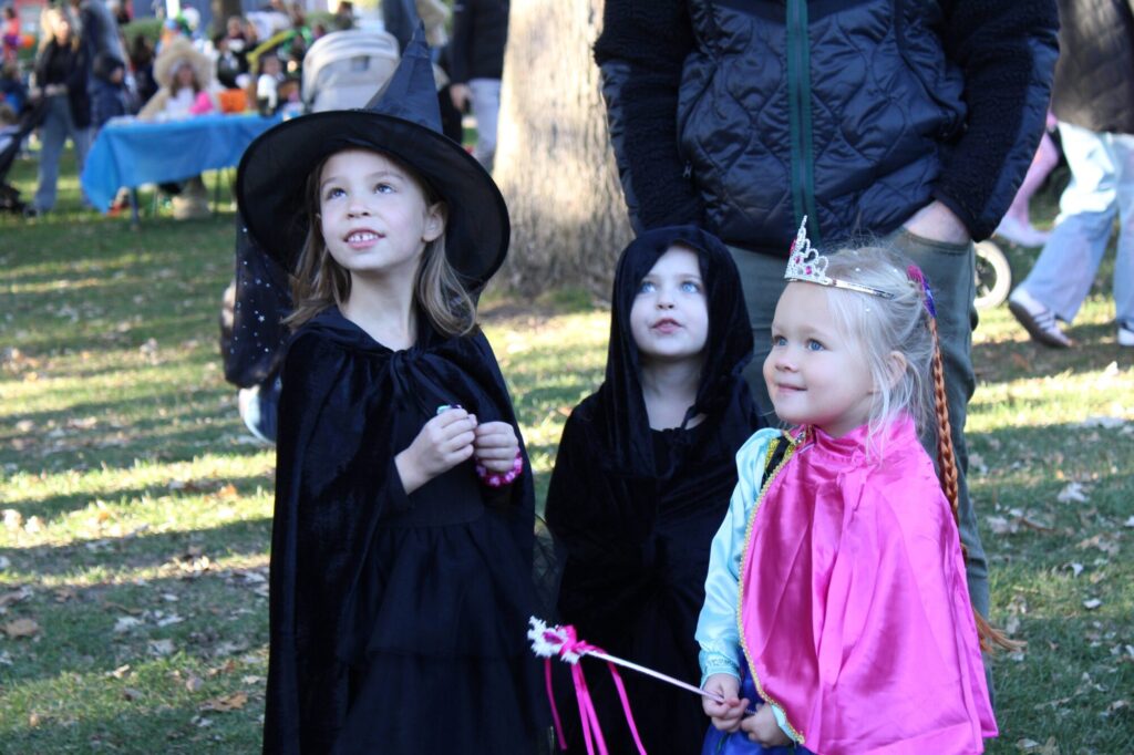 Group of three young girls dressed as witches and princesses smiling
