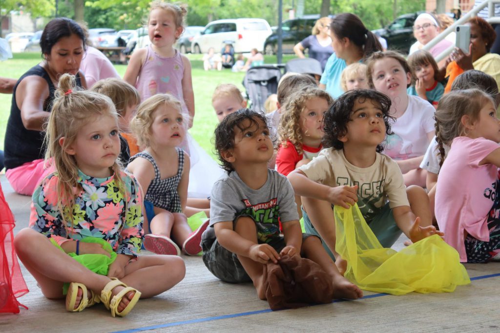 Children sitting and watching a concert.