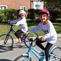 two young girls riding bicycles