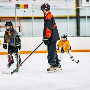 Three individuals playing hockey.