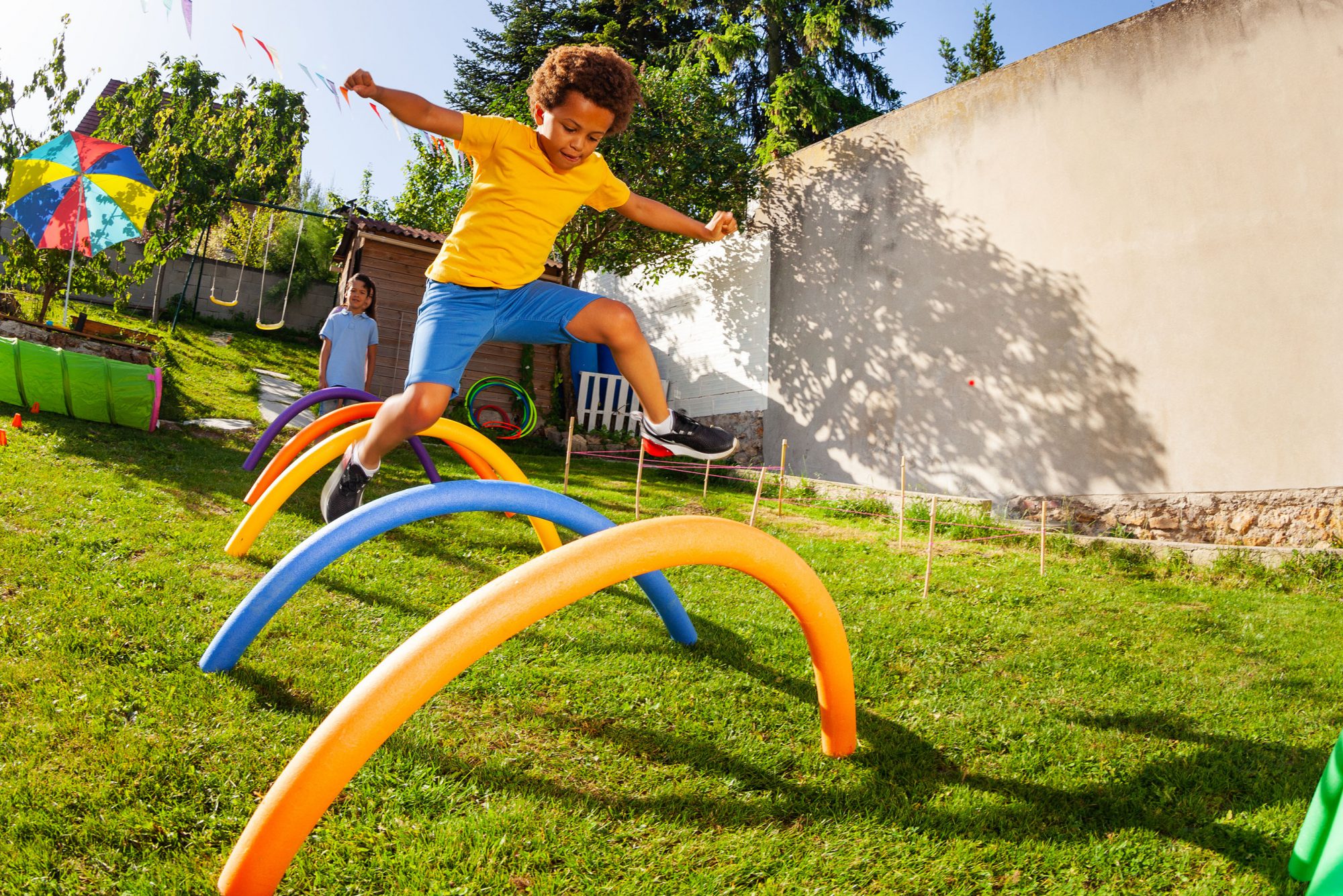 child running through an obstacle course in a backyard