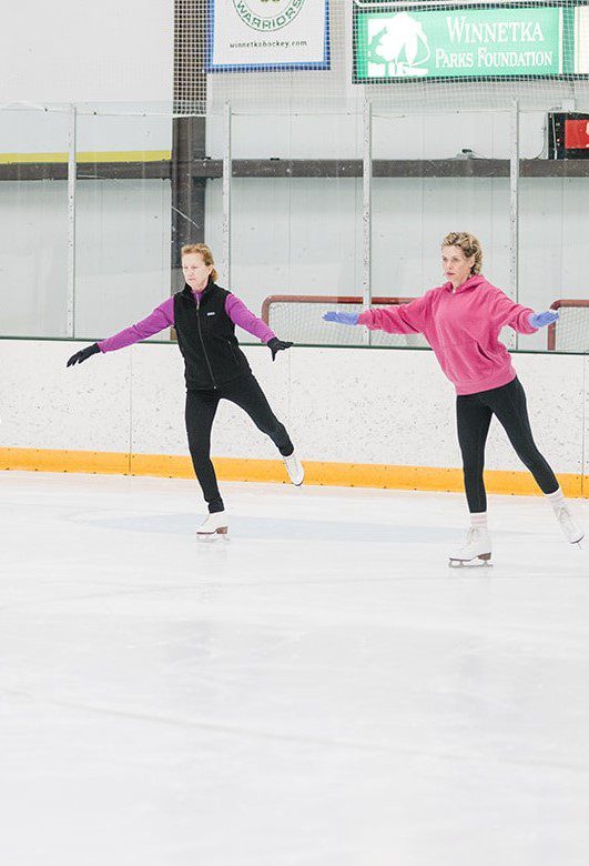 two adult woman taking an ice skating class
